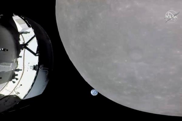 This screengrab from NASA TV shows NASA's Orion capsule, left, nearing the moon, right, Monday, Nov. 21, 2022.